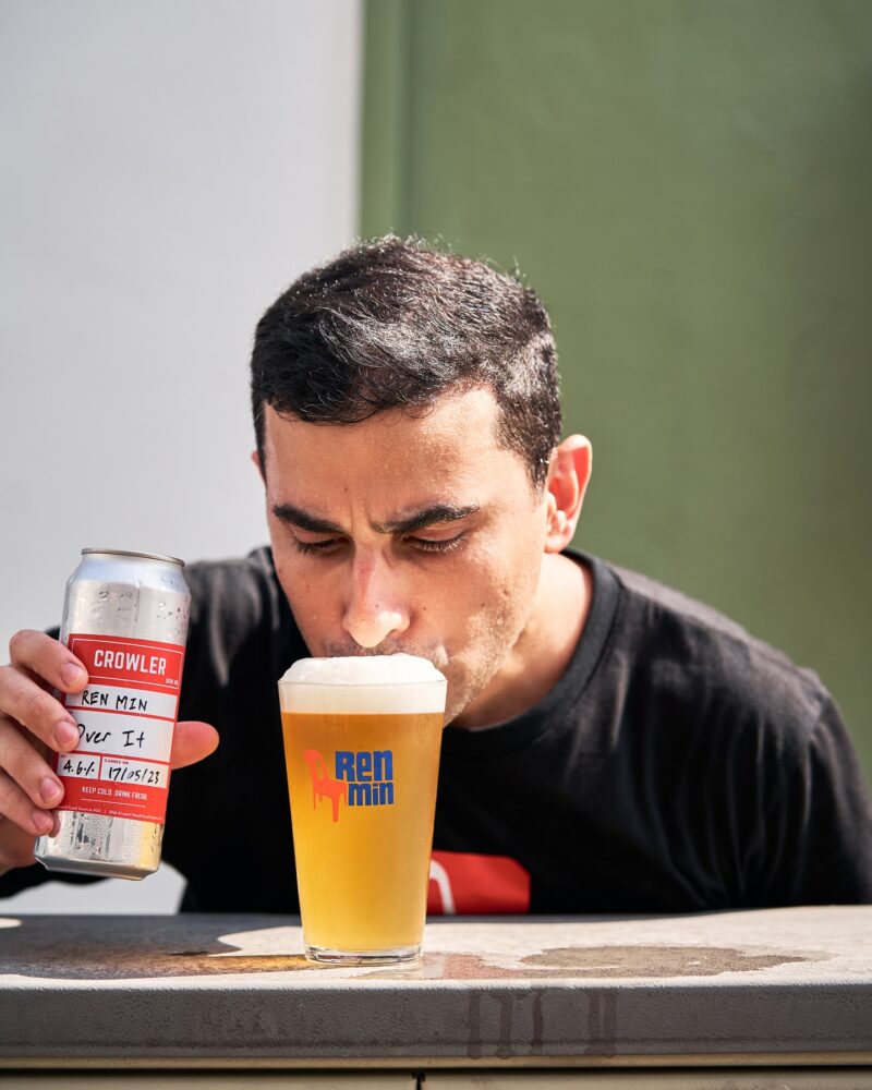 Man drinking Renmin craft beer from a glass